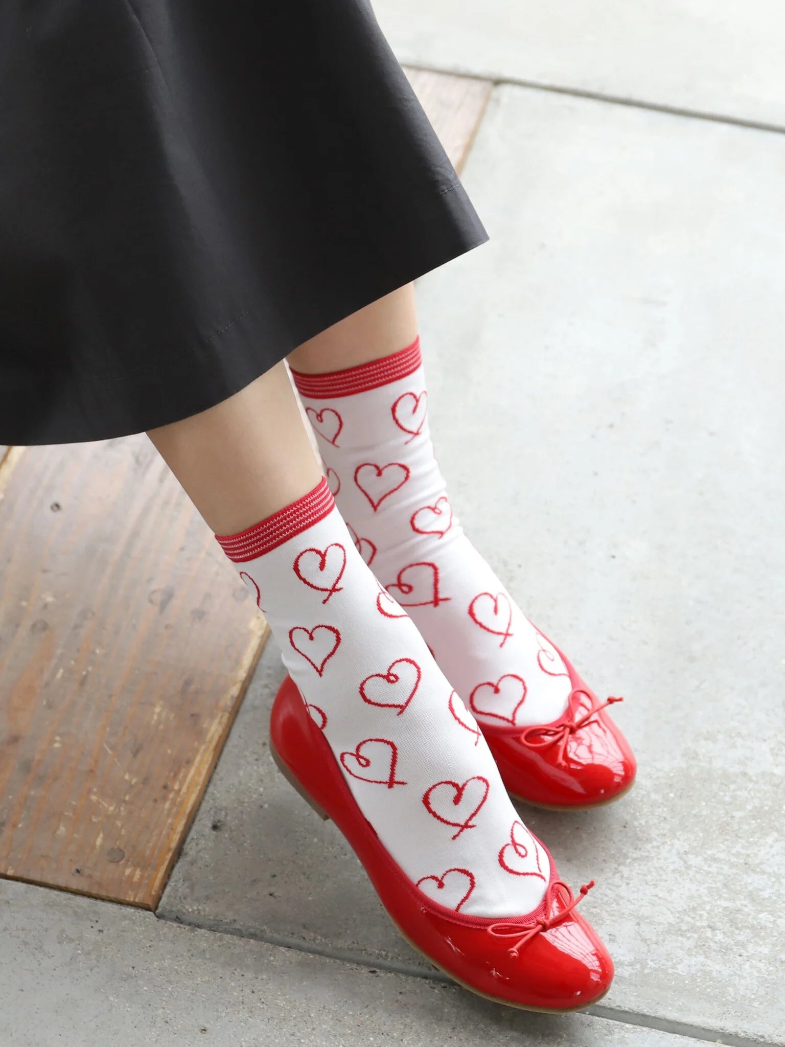 Tabio Heart Drawing Low Crew Socks in white and red feature a playful heart pattern, styled with cute red flats.