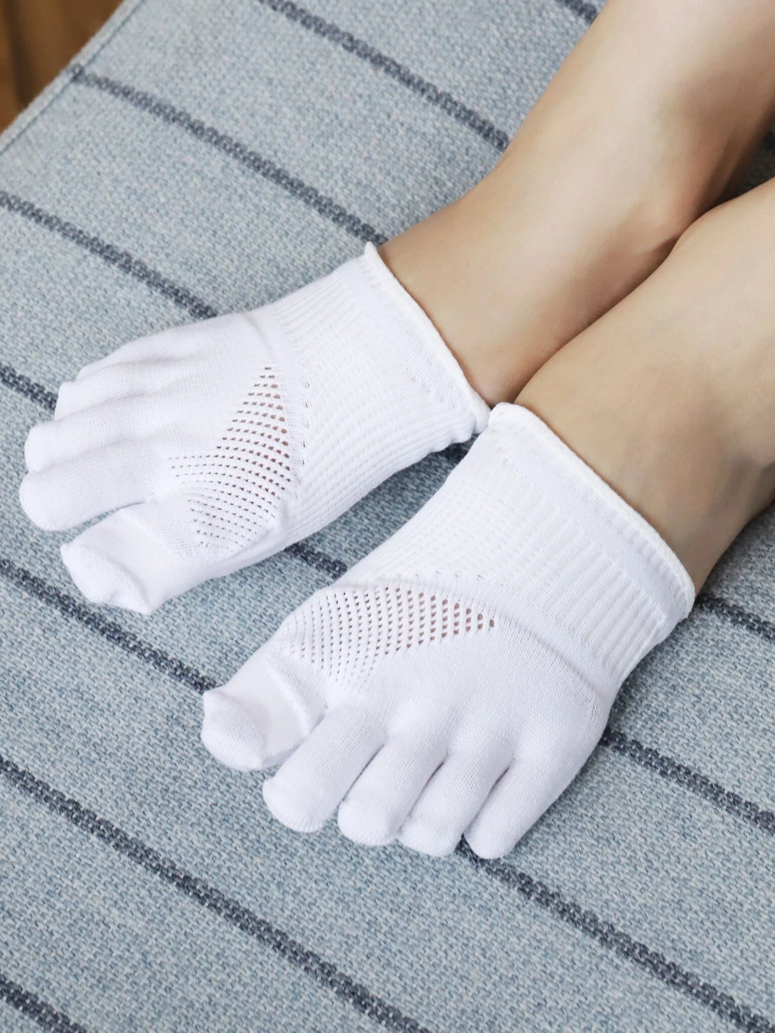 Tabio Toe Cover For Hallux Valgus shown worn on feet, featuring separated toes and breathable fabric to alleviate bunion.