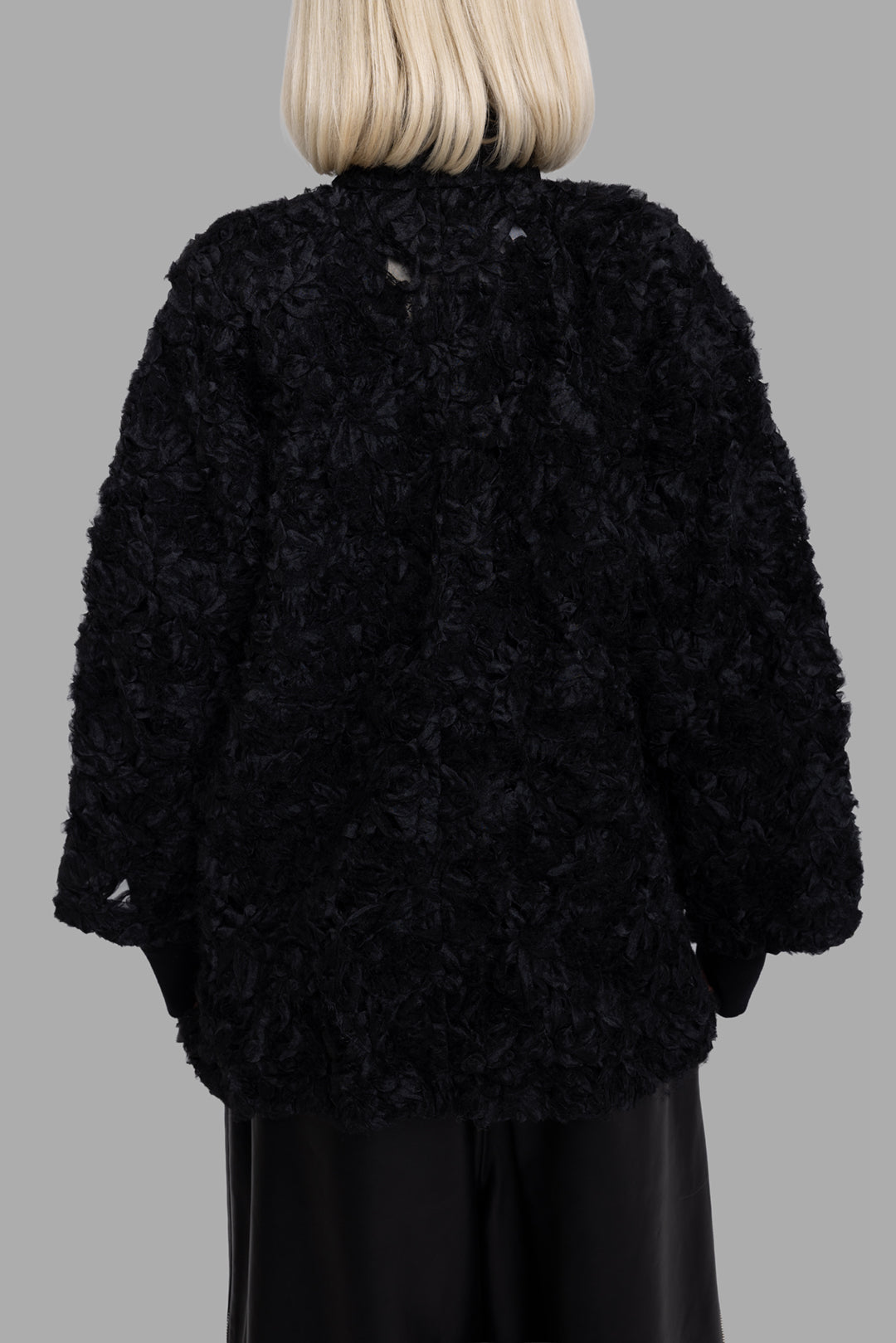 Comme des Garçons women's black textured quilted jacket, back view, boxy silhouette with all-over 3D floral texture.