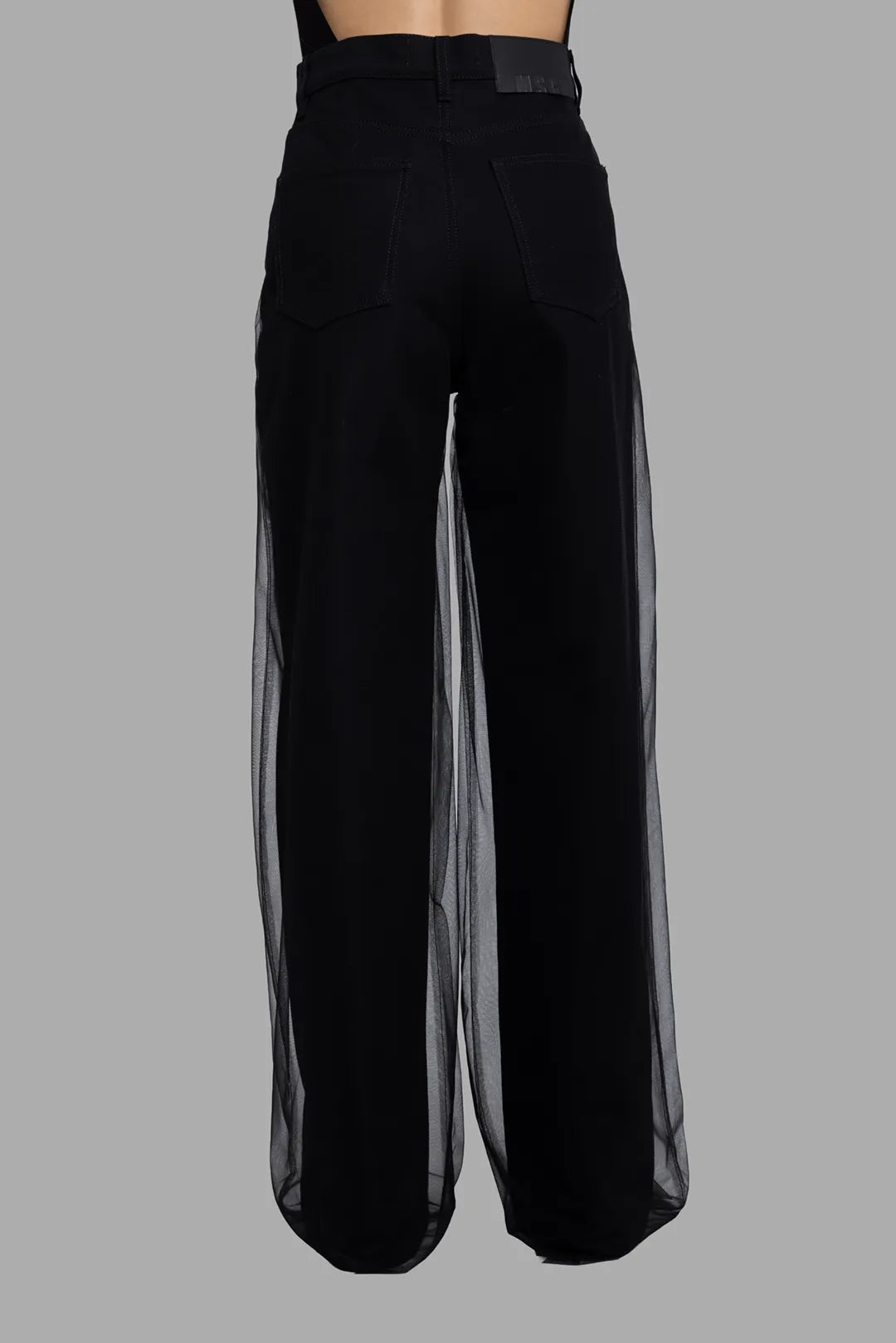 MSGM women's black denim jeans with tulle overlay, back view, patch pockets and sheer side panels.