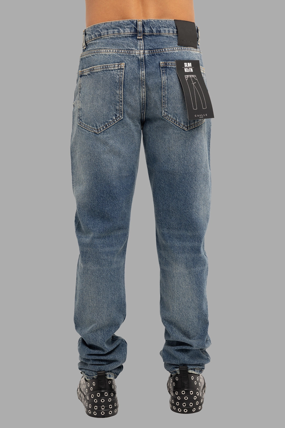Gaelle Paris men’s jeans in blue, back view, leather logo patch and visible “Slim Keith” hangtag