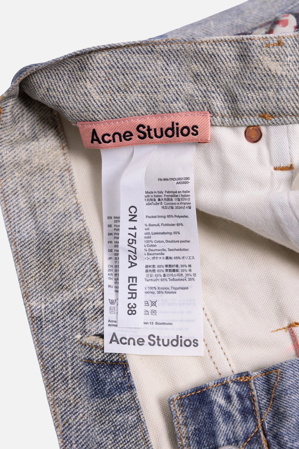 Acne Studios women's pre-owned jeans in mid blue, close-up view, printed chain links and charm cluster beside pocket