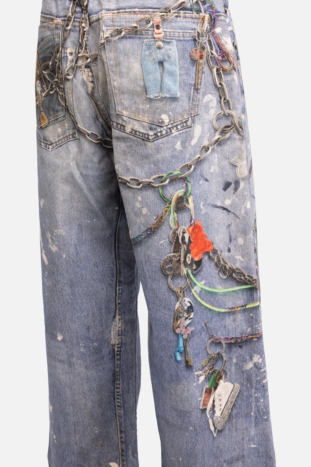 Acne Studios women's pre-owned jeans in mid blue, side view, printed charms with red bear and mini sneaker