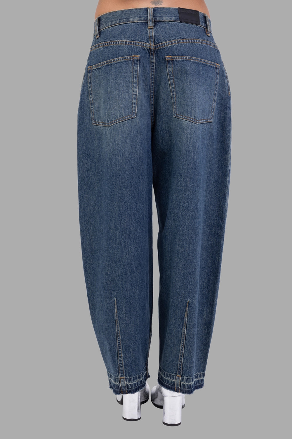 Helmut Lang women cocoon jeans in Tinted Vintage, back view, curved outseams and leather logo patch.
