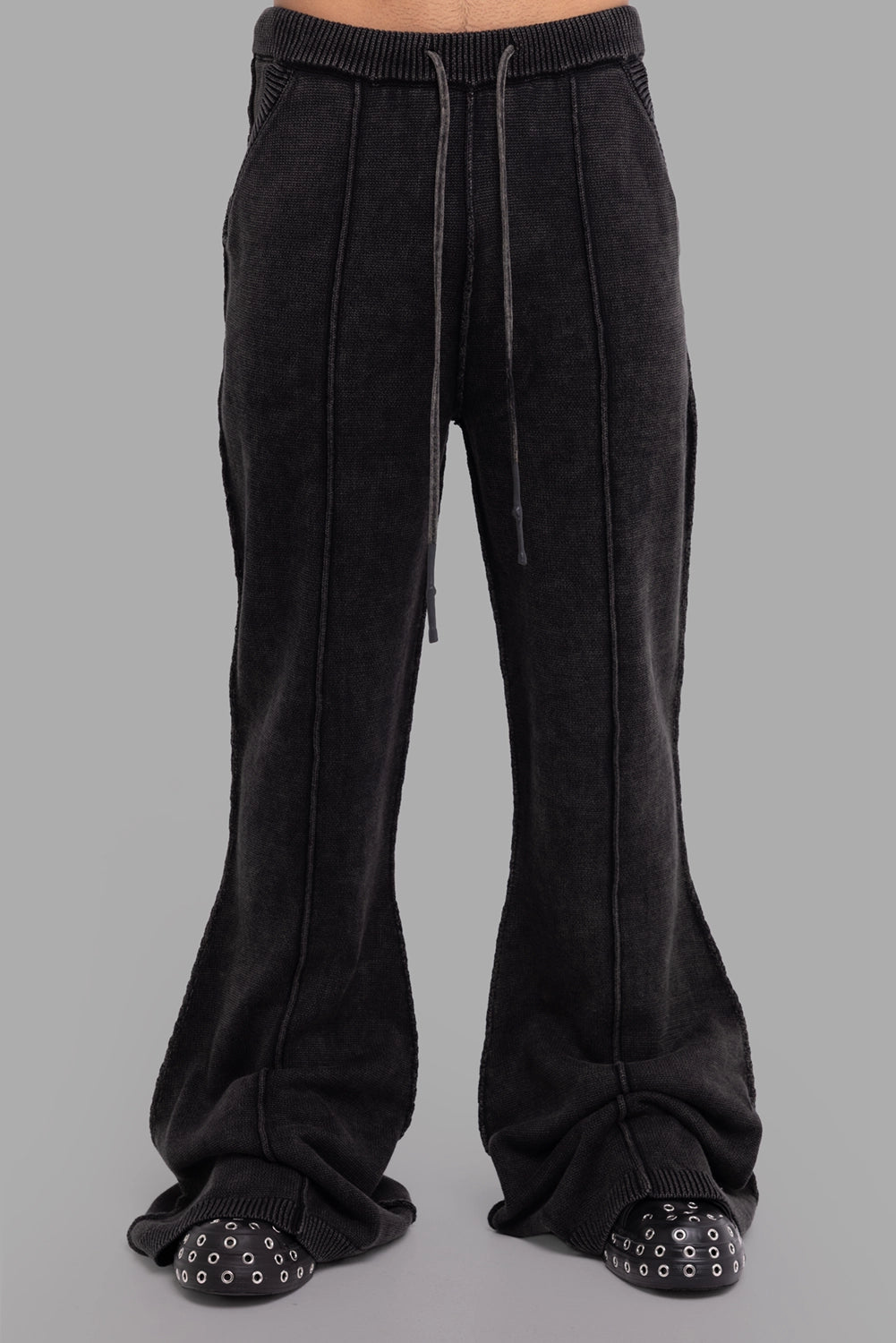 Justin Gall men’s knit pants in black, front view, ribbed waistband with long drawcords and vertical outseams.