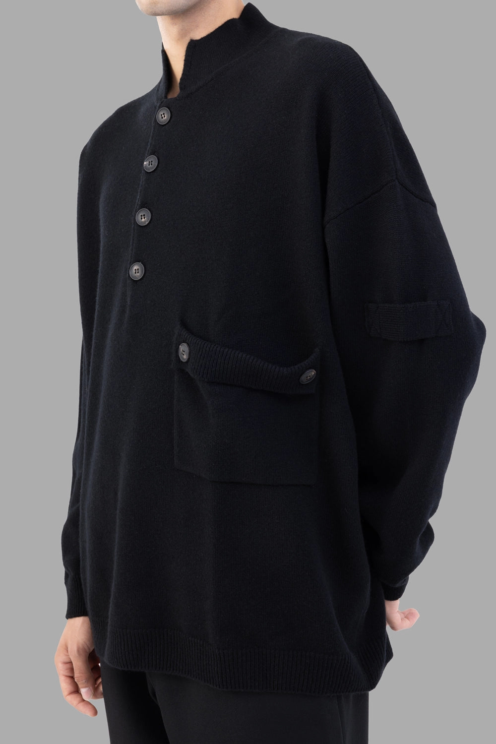 AION knit pullover in black, 3/4 view, buttoned flap pocket detail