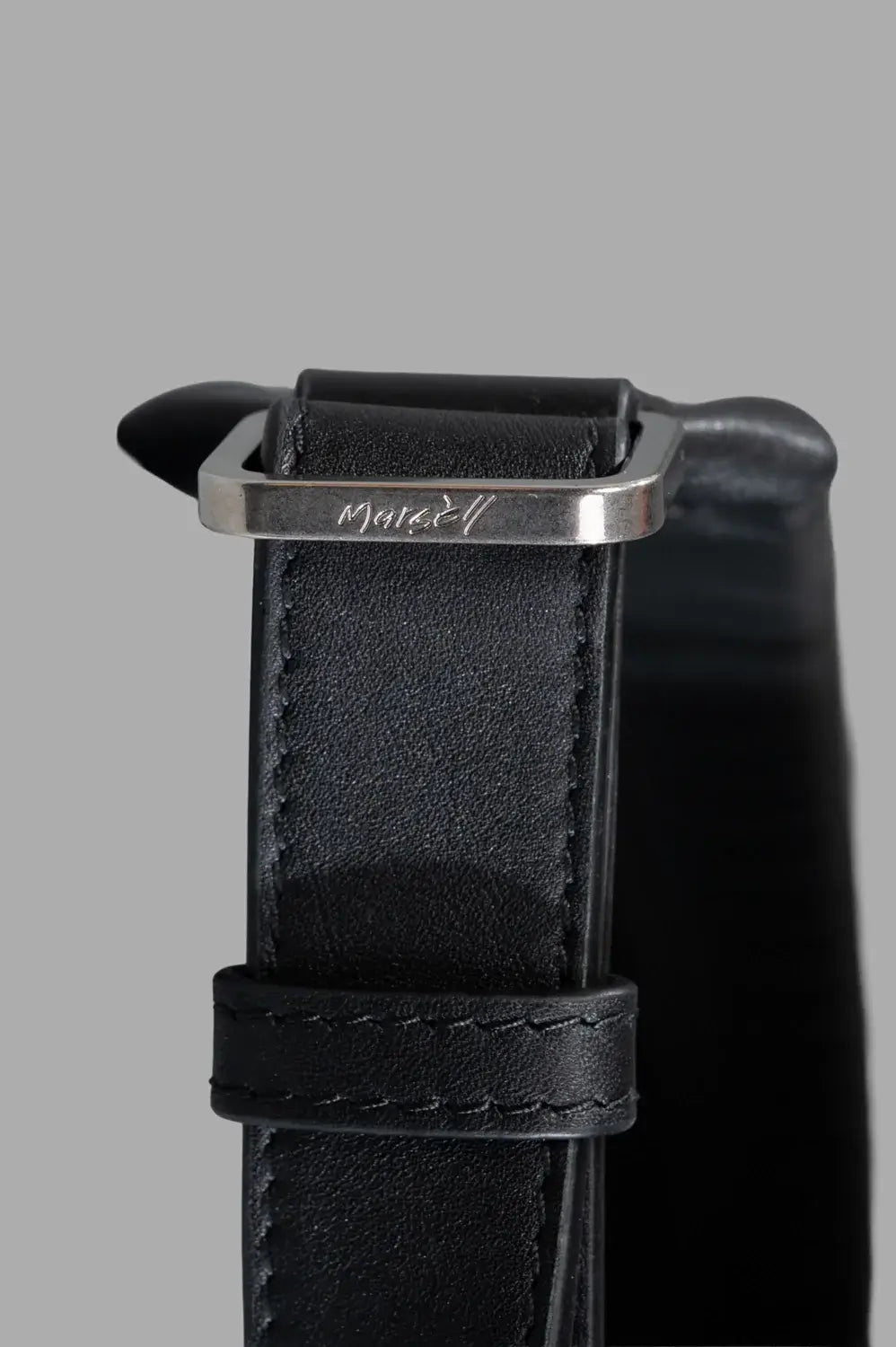 Marsèll laptop bag in black, hardware close-up, engraved buckle on strap