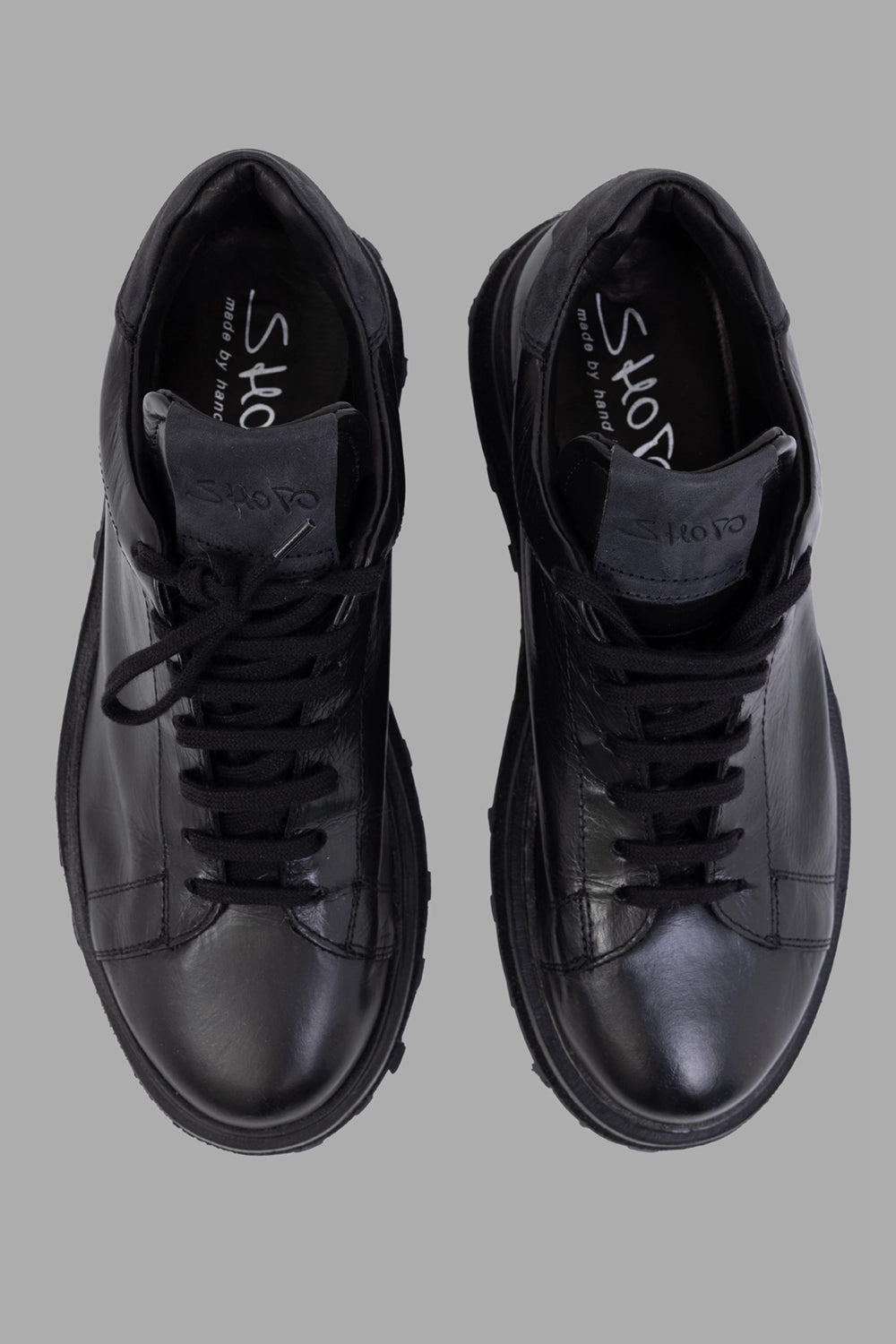 Shoto unisex leather low-top sneakers in black, top view, embossed tongue logo and clean stitching