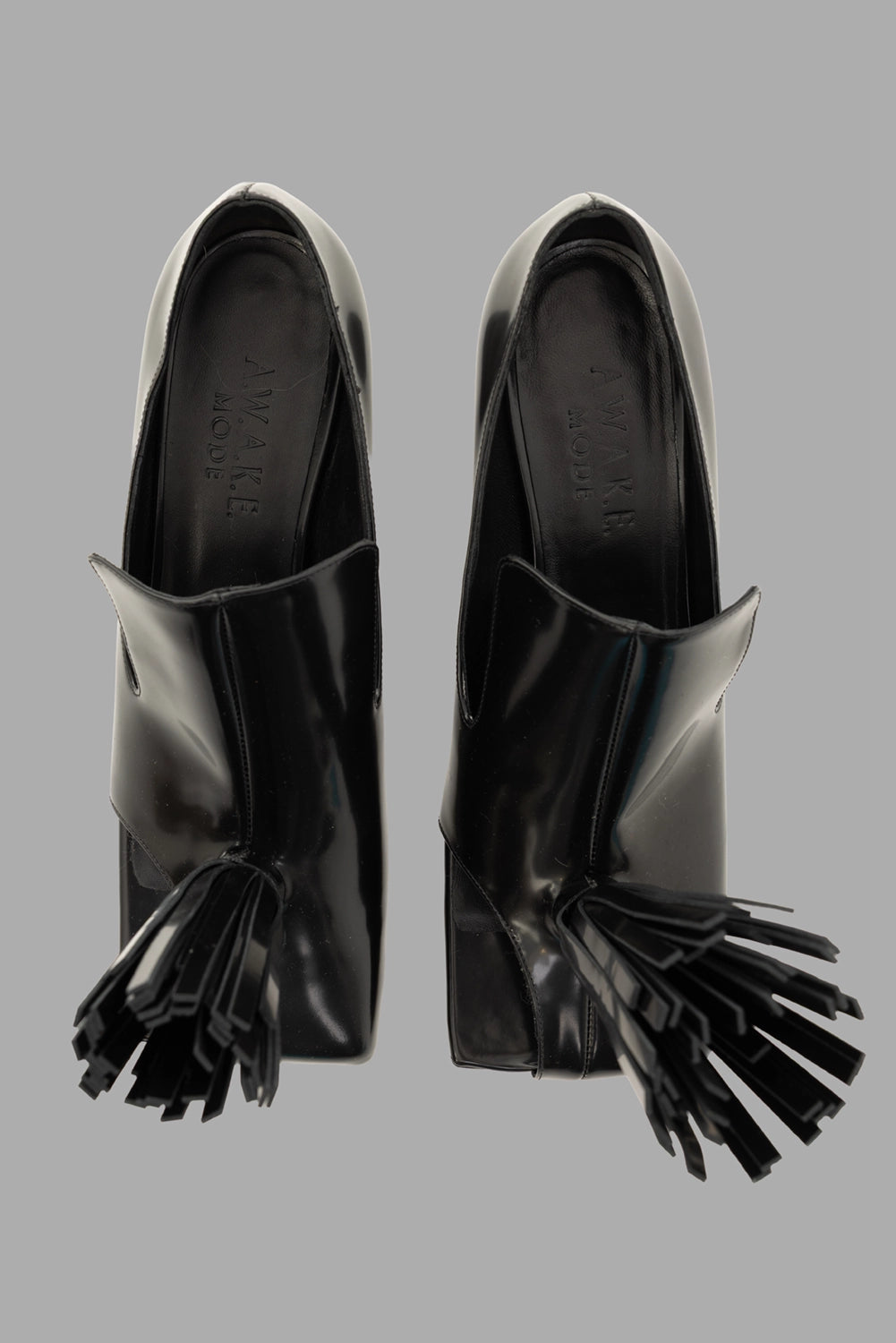 A.W.A.K.E. MODE women loafers in black, top view, asymmetric opening, logo-embossed insole and tassel detail.