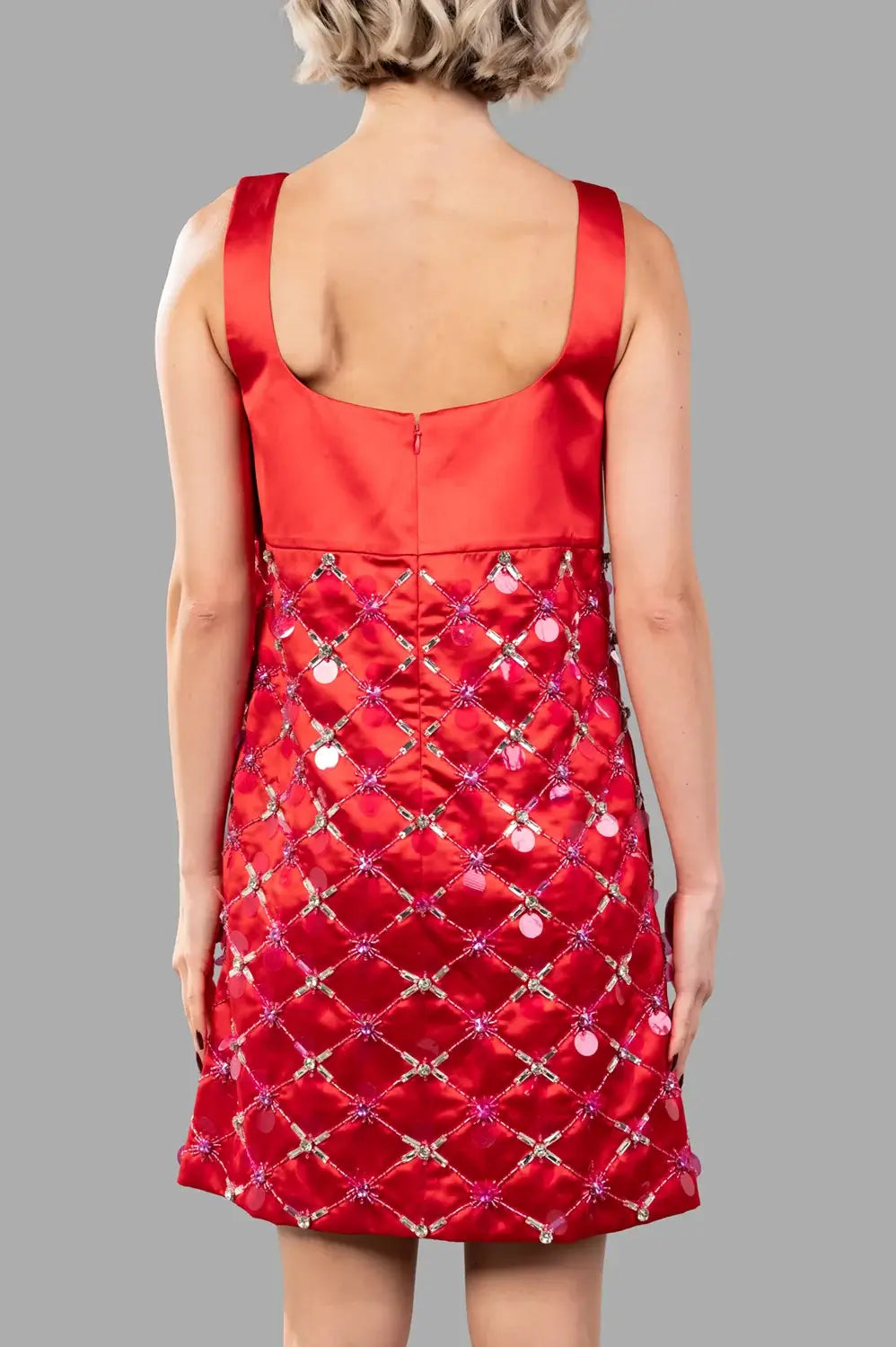 Close-up of crystal and sequin lattice embellishment across the red skirt.