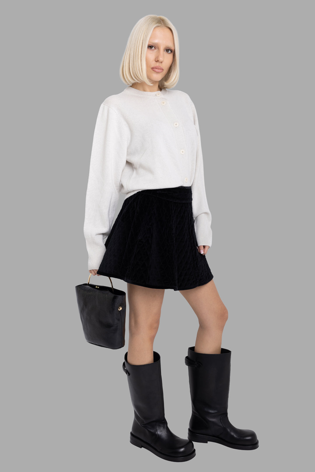 Vivienne Westwood women's black quilted velvet mini skirt, on-model full length, skater A-line silhouette.