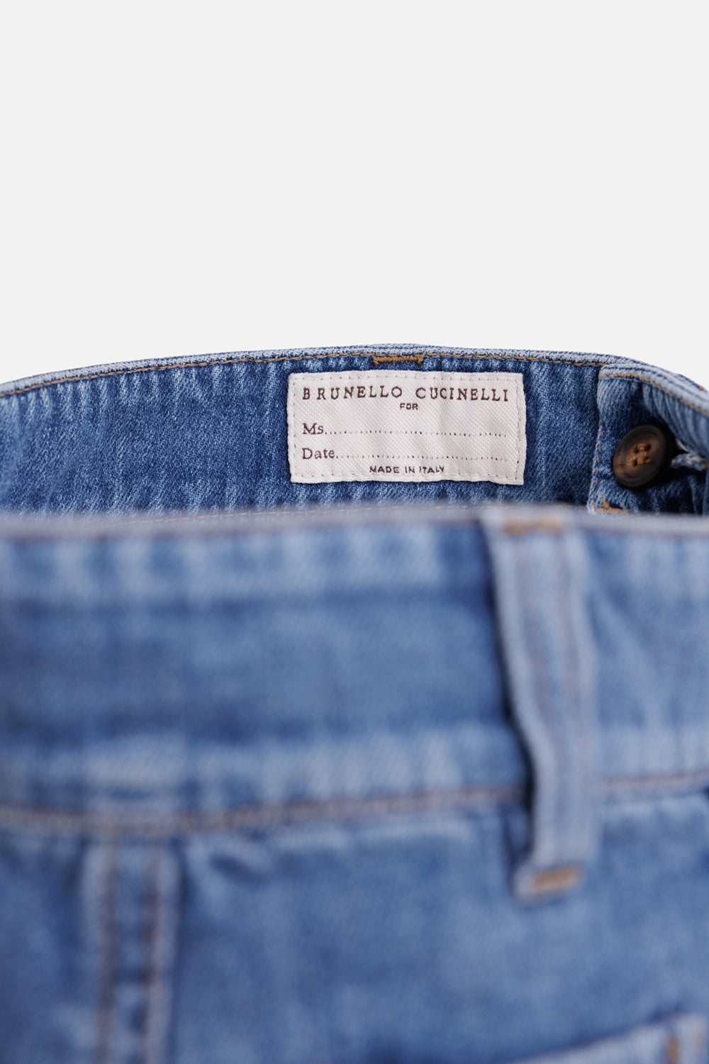 Brunello Cucinelli women's straight-leg jeans in blue, label detail with white name tag and brown button
