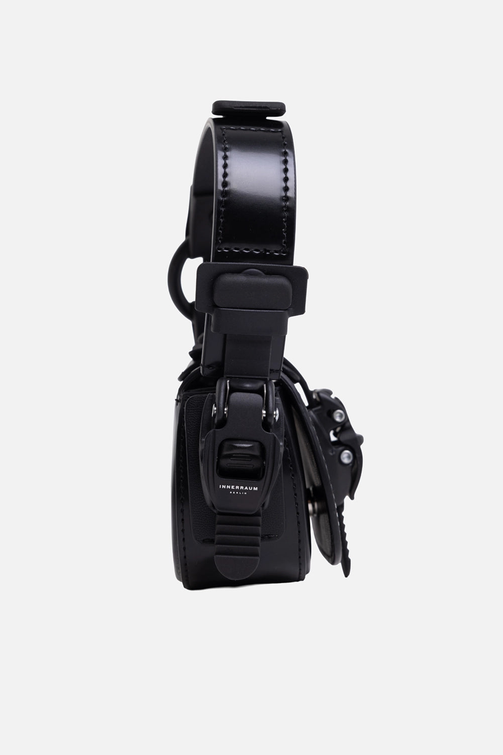 INNERAUM Berlin unisex nano crossbody bag in black, side view, matte clasp and curved handle