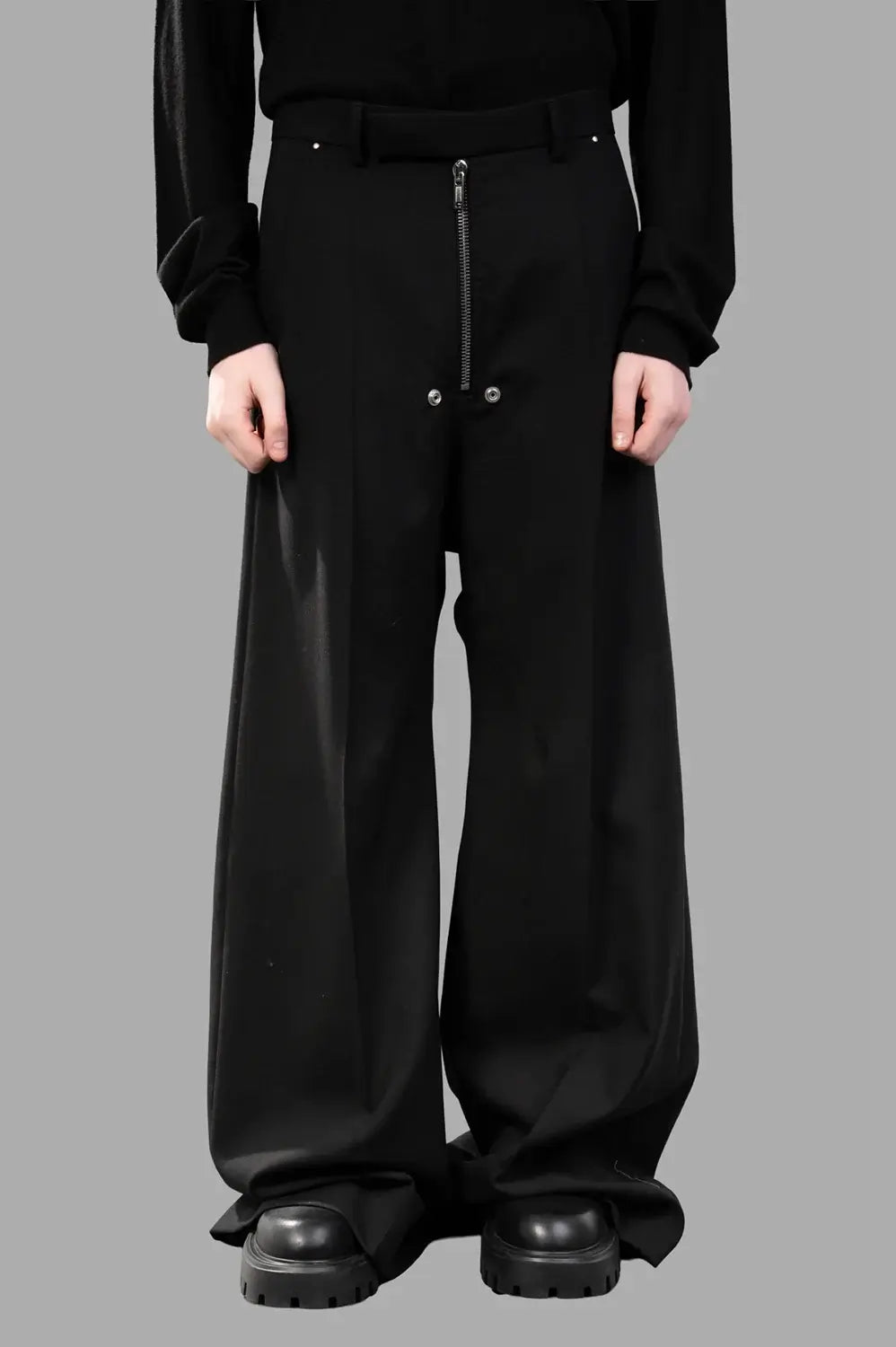 Rick Owens wide-leg pants in black wool‑blend, front view, zip and hook closure and hardware rivets