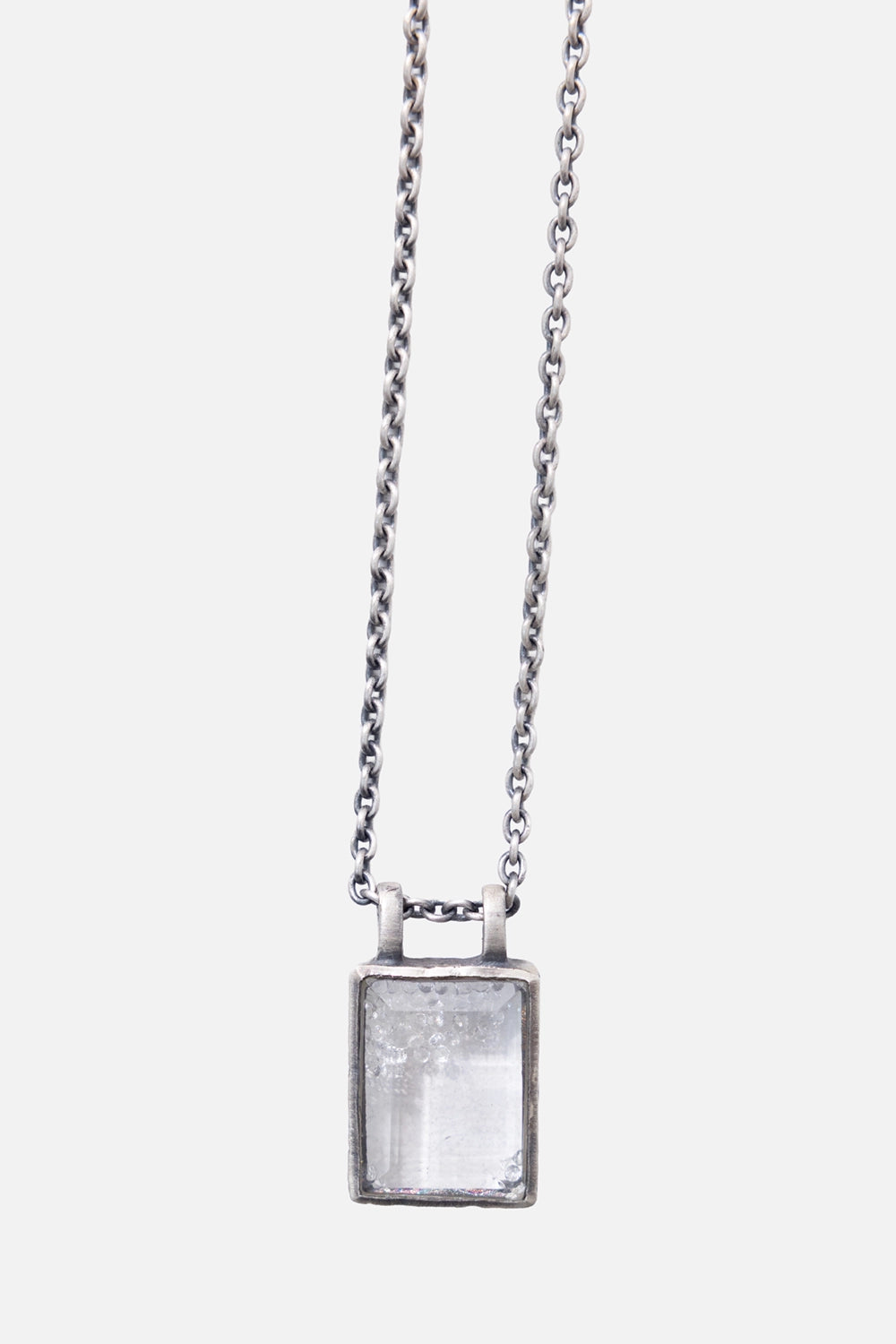Kundo unisex topaz pendant necklace in silver and clear, close-up with rectangular stone and twin-loop setting