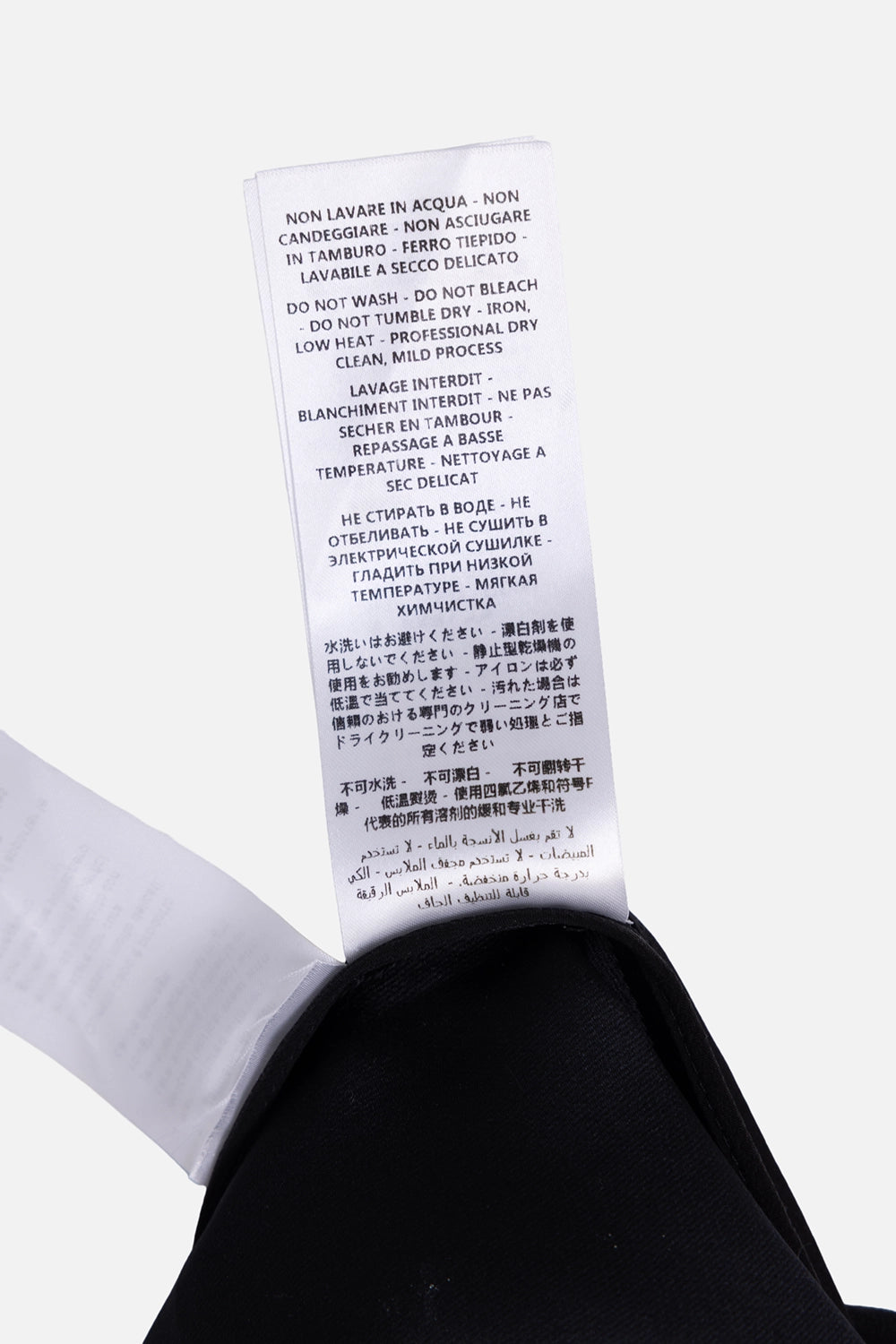 Pre-owned Saint Laurent playsuit in black, care label close-up, washing and dry-clean instructions