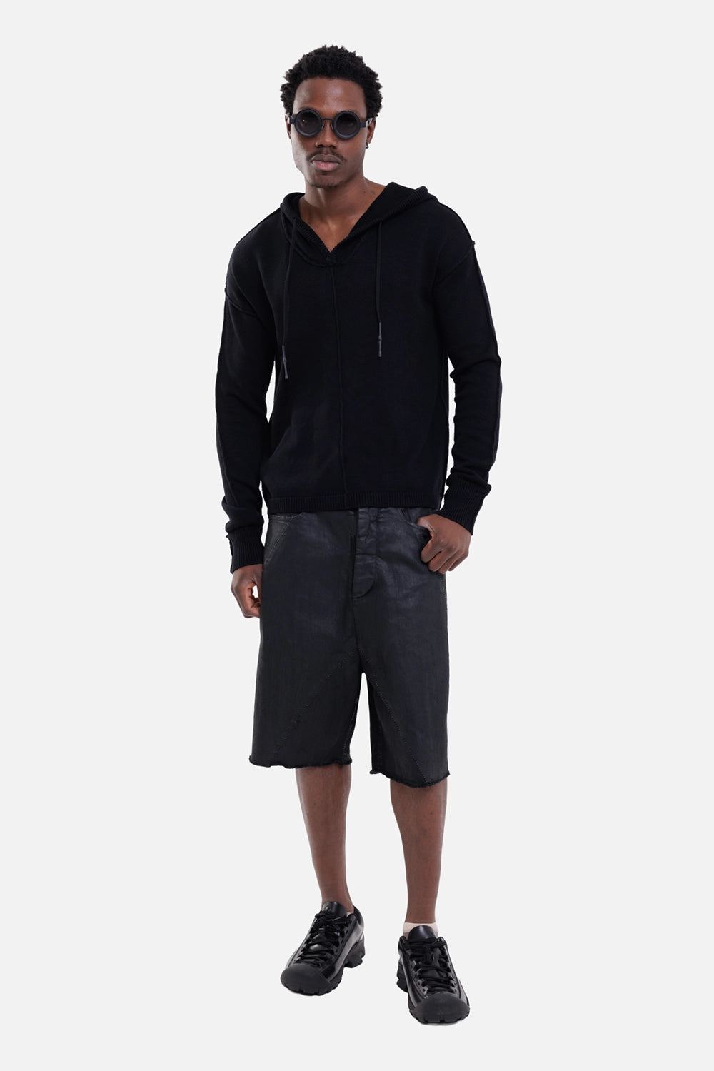 Justin Gall men's knit hoodie in black, on-model full-length view, drawcord hood and ribbed cuffs