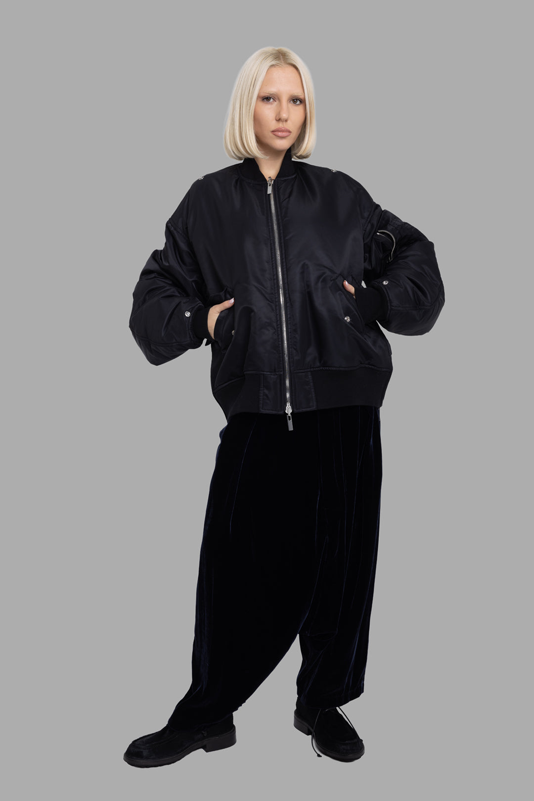 Comme des Garçons women's black bomber jacket, on-model full length, oversized MA-1 shape with ribbed hem.