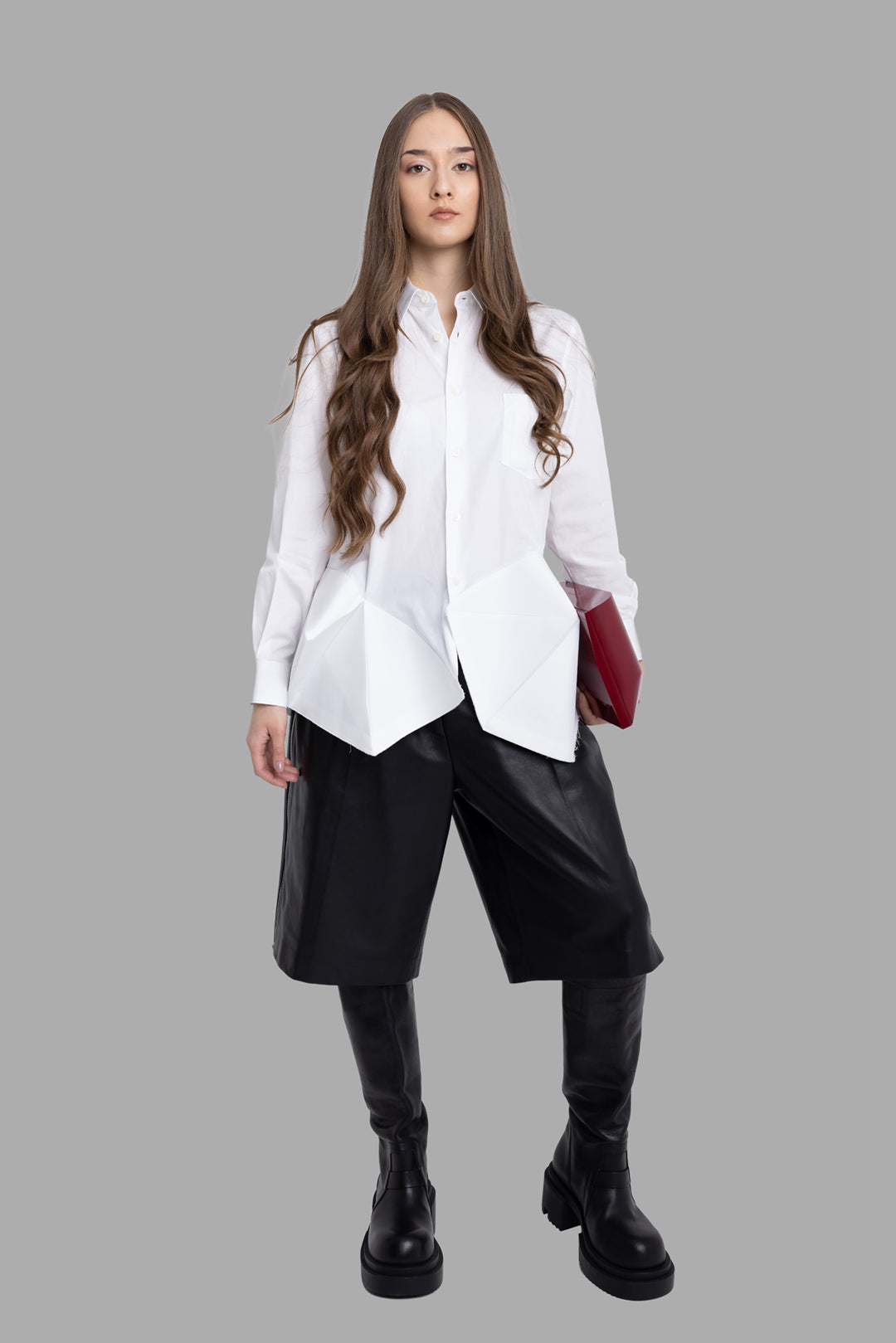Comme des Garçons women's white ruffle bottom shirt, on-model full length, origami hem panels over wide black shorts.