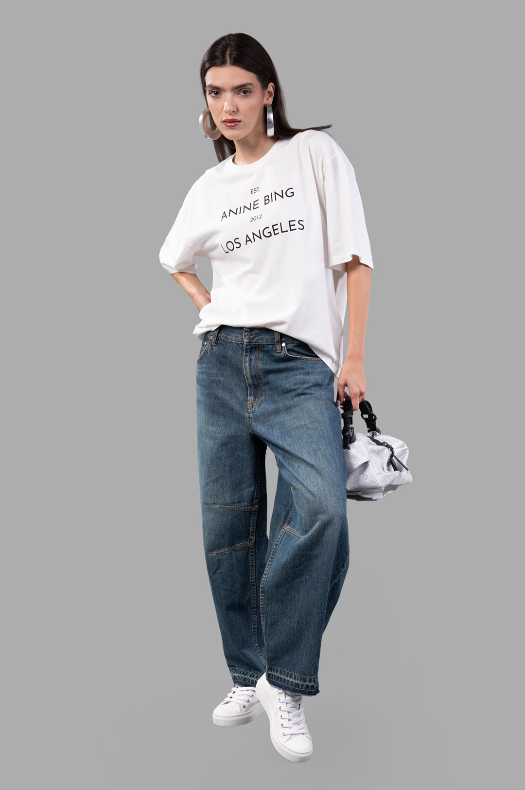 Helmut Lang Cocoon Jeans, front view on model, vintage blue barrel-leg denim with released hem and sculpted curved leg design.