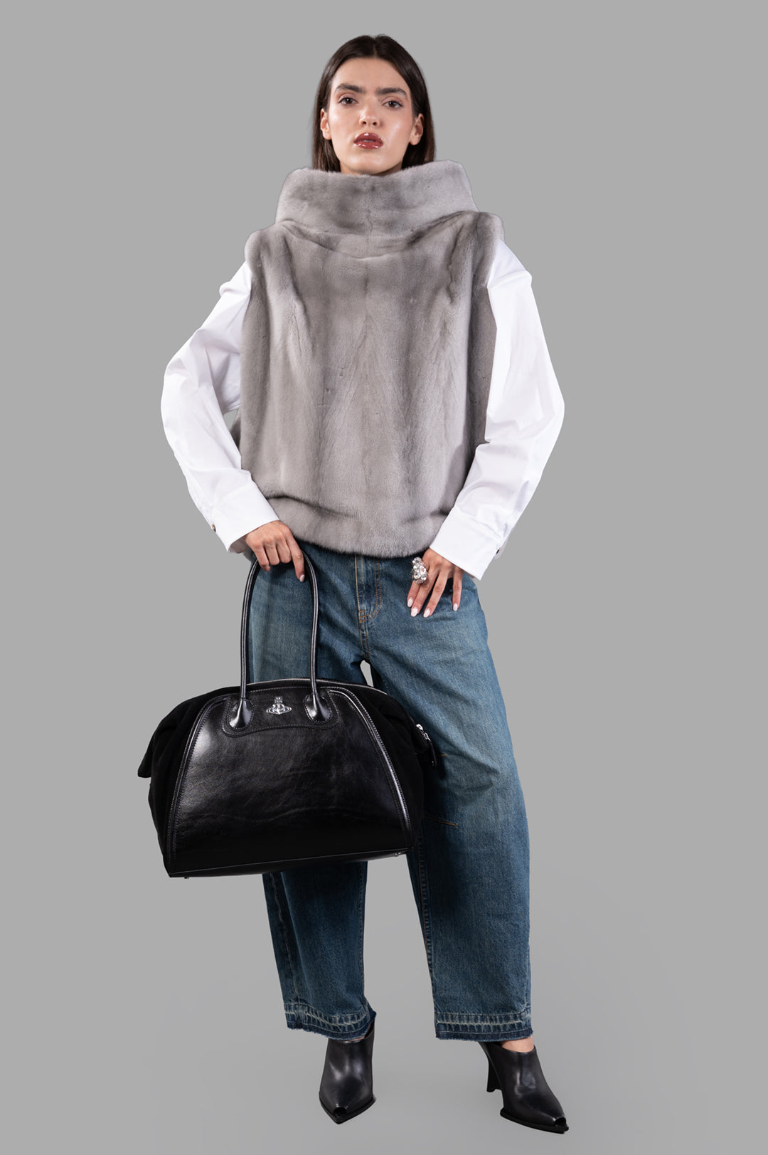 Inès & Maréchal Fur Vest in grey on model, showcasing front view, paired with jeans, white shirt, and black bag.