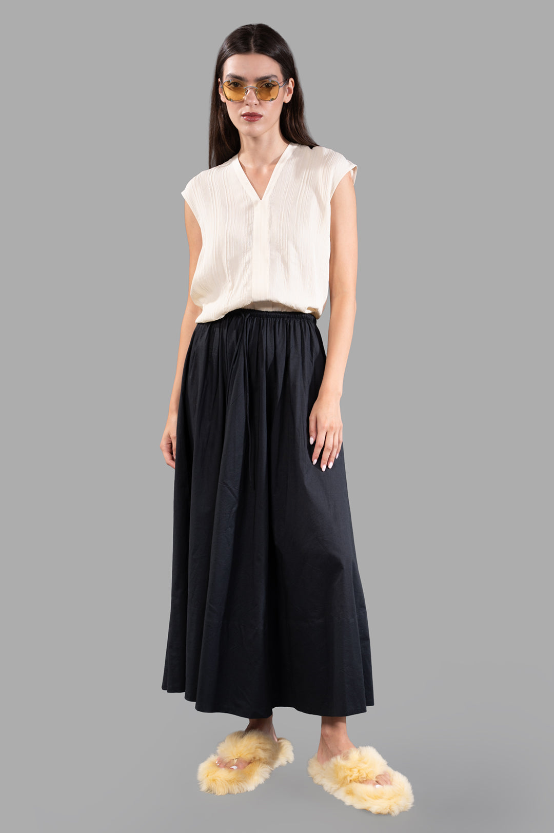 By Malene Birger Pheobes Cotton Skirt; front view on model, loose black maxi skirt, high-waist elastic band.