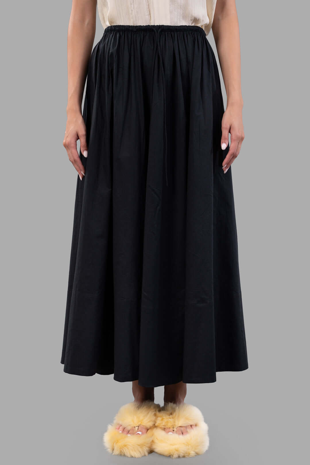 By Malene Birger Pheobes Cotton Skirt in black, featuring a high-waisted elastic band and loose silhouette, on model.