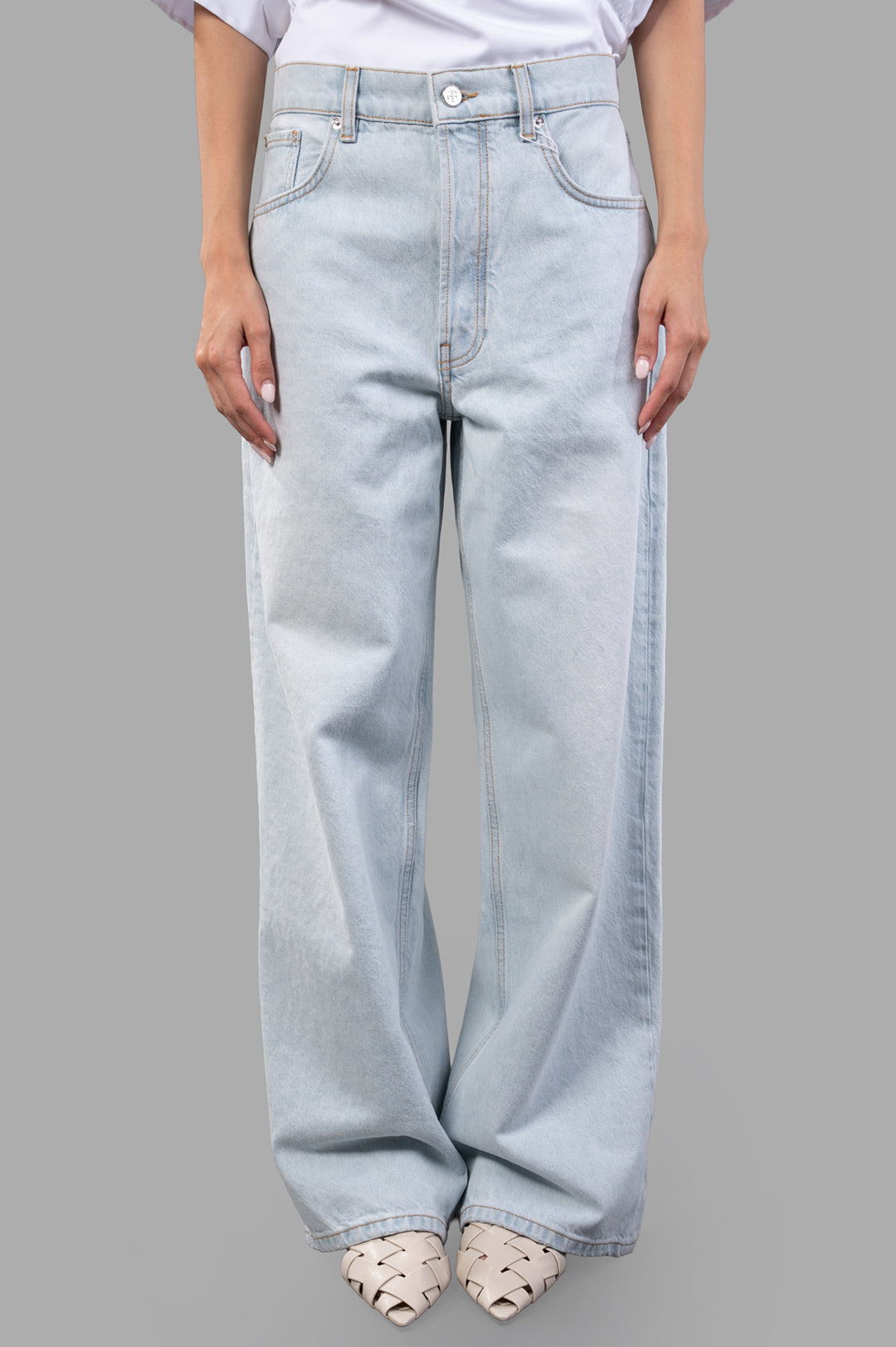 Anine Bing Manon Jeans showcasing a baggy fit in ultra-bleached blue cotton, styled with elegant heels.