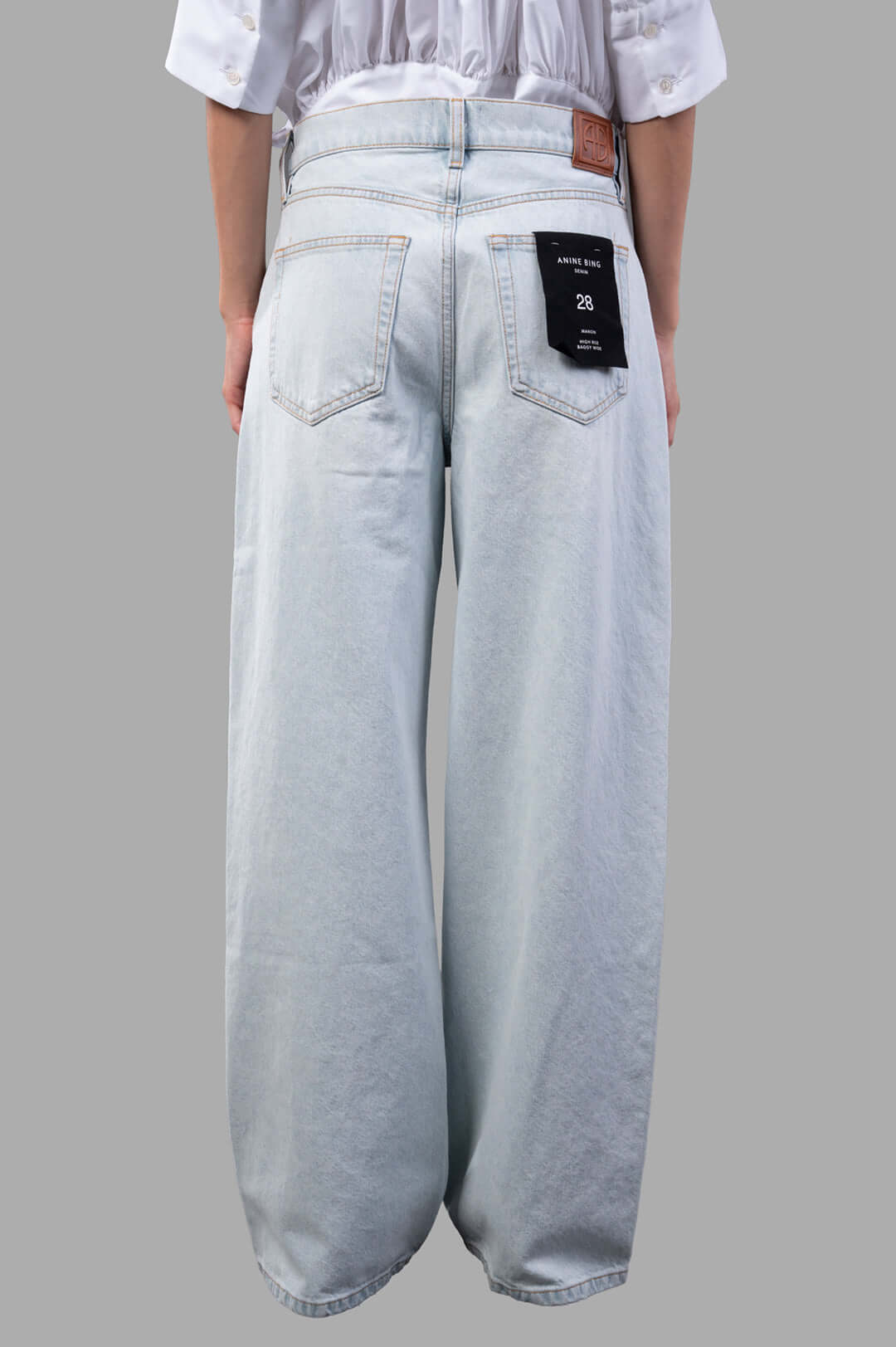 Anine Bing Manon Jeans featuring a baggy silhouette in ultra-bleached blue wash, shown from the back with tag detail.