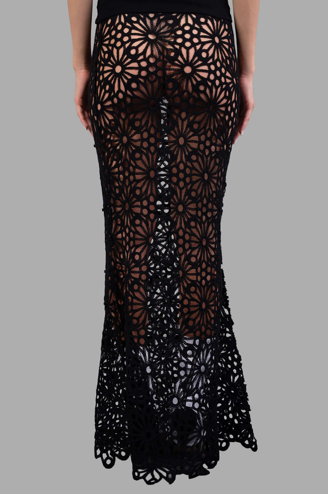 Norma Kamali Obie Long Skirt shown from the back, highlighting sheer fabric, floral details, and fishtail hem design.