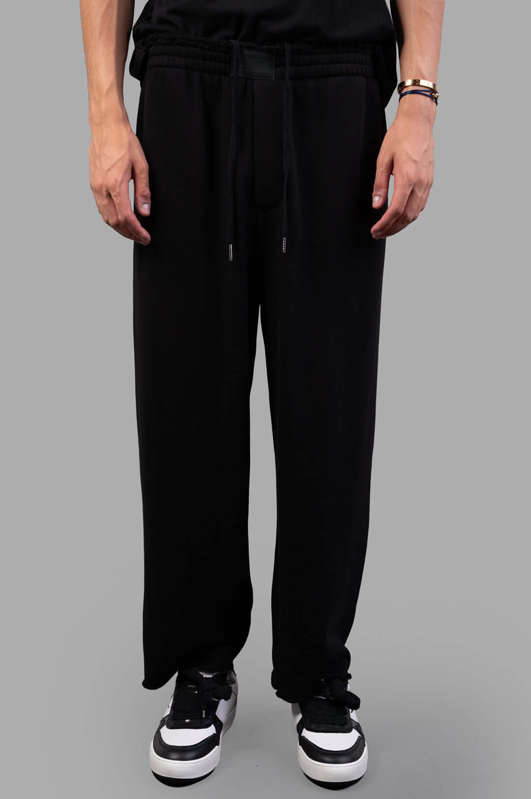 Helmut Lang Minimal Sweatpants in black, featuring a rubber logo patch, elastic waistband, and relaxed fit. 100% cotton.