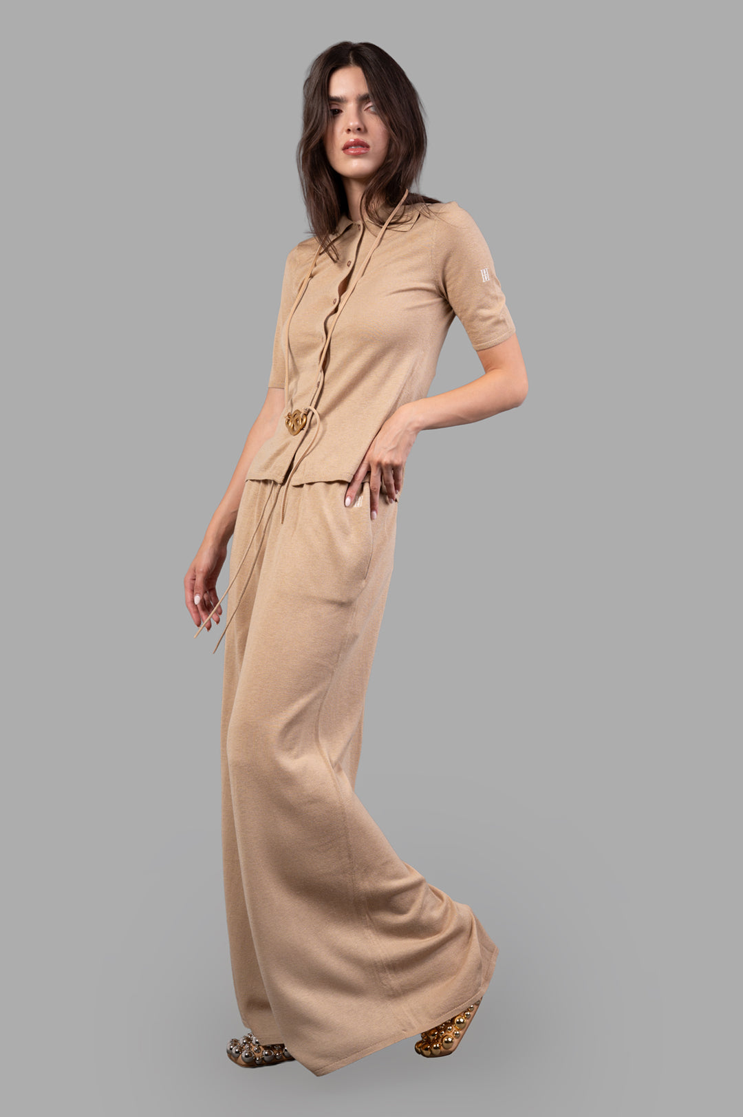 By Malene Birger Drawstring Trousers in beige, front view worn, wide legs, adjustable tie waist, small embroidered monogram.