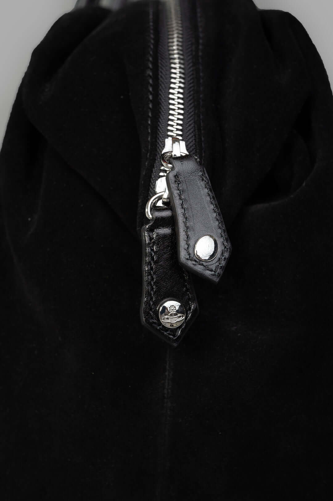 Vivienne Westwood Shirley Holdall close-up of the zipper and branded pull tabs, highlighting craftsmanship in smooth leather.