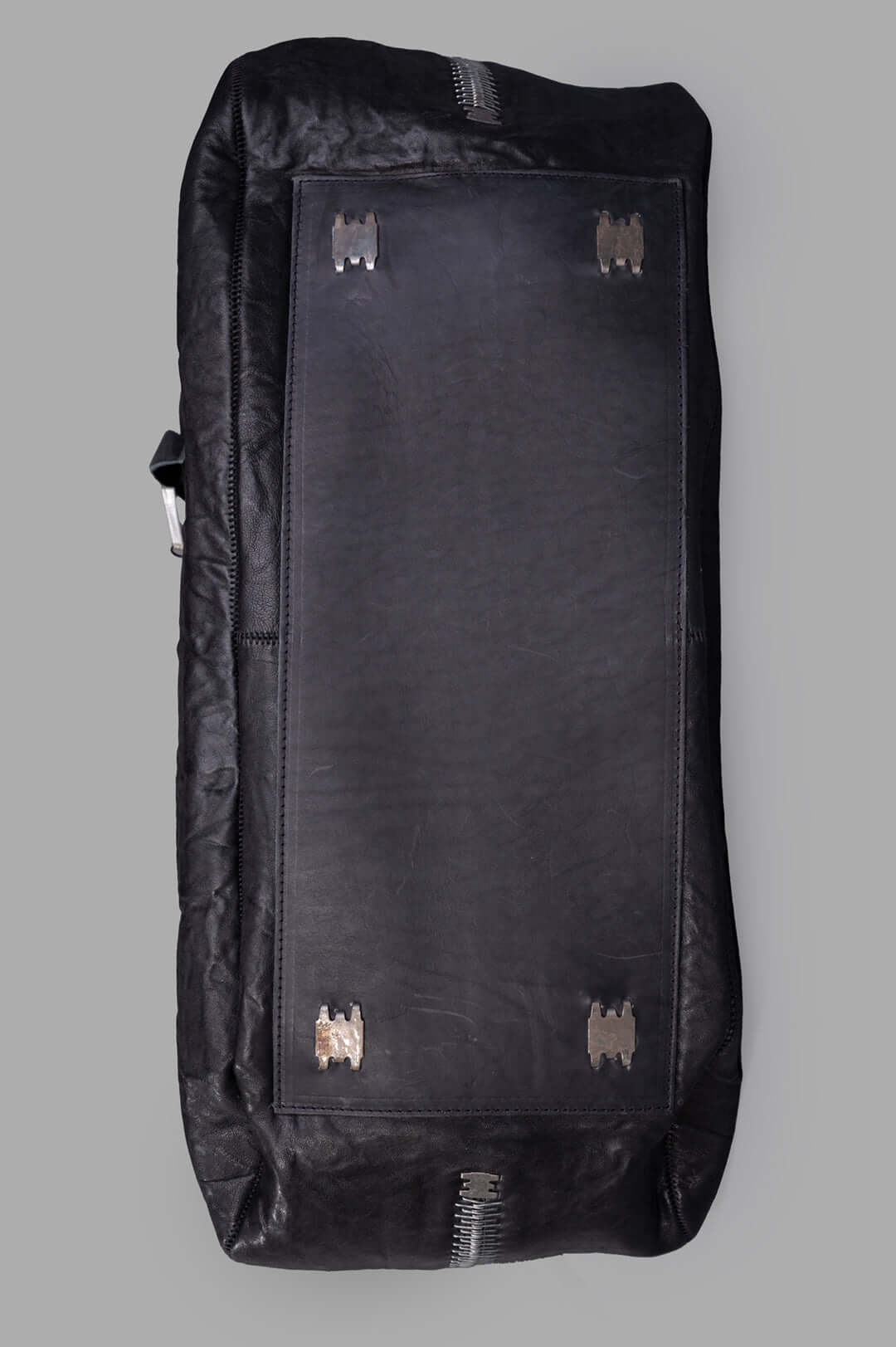 Isaac Sellam. Oversized Leather Bag showing the durable crinkled leather texture and unique metallic accents on the bottom.