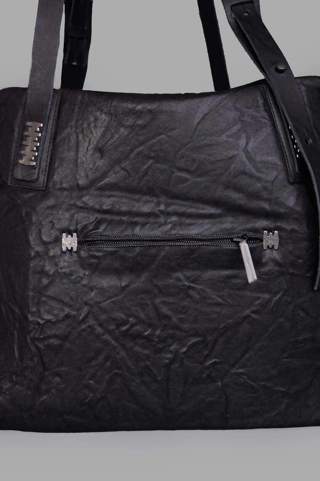 Isaac Sellam. Close-up of the Oversized Leather Bag showcasing textured crinkled black leather and functional zip pocket.