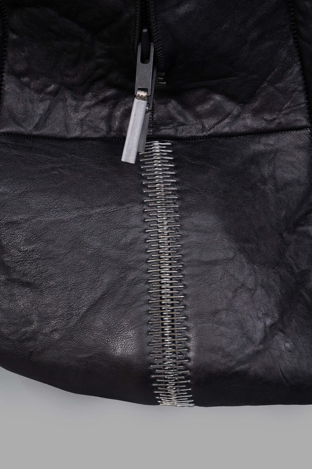 Isaac Sellam Oversized Leather Bag close-up showing durable crinkled leather and metal zipper detailing. Ideal for travel.