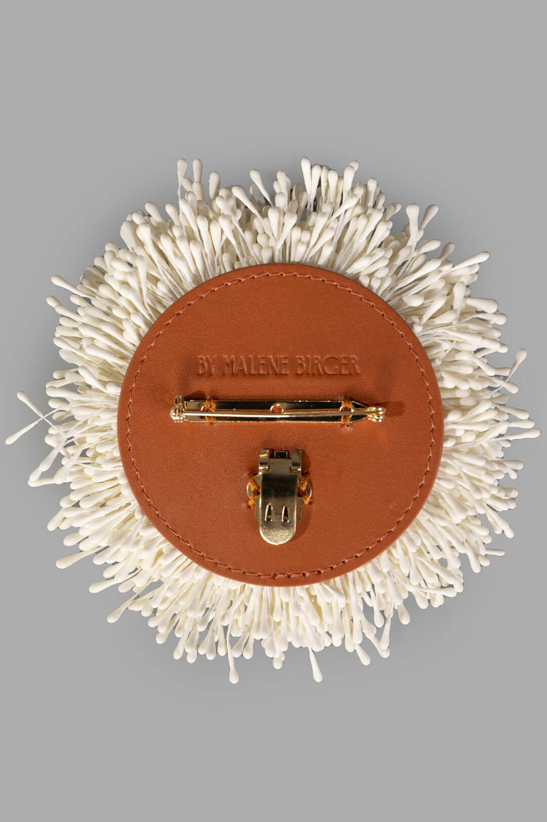 By Malene Birger Henna Brooch in White, featuring a floral design with a gold tube hinge and leather backing.
