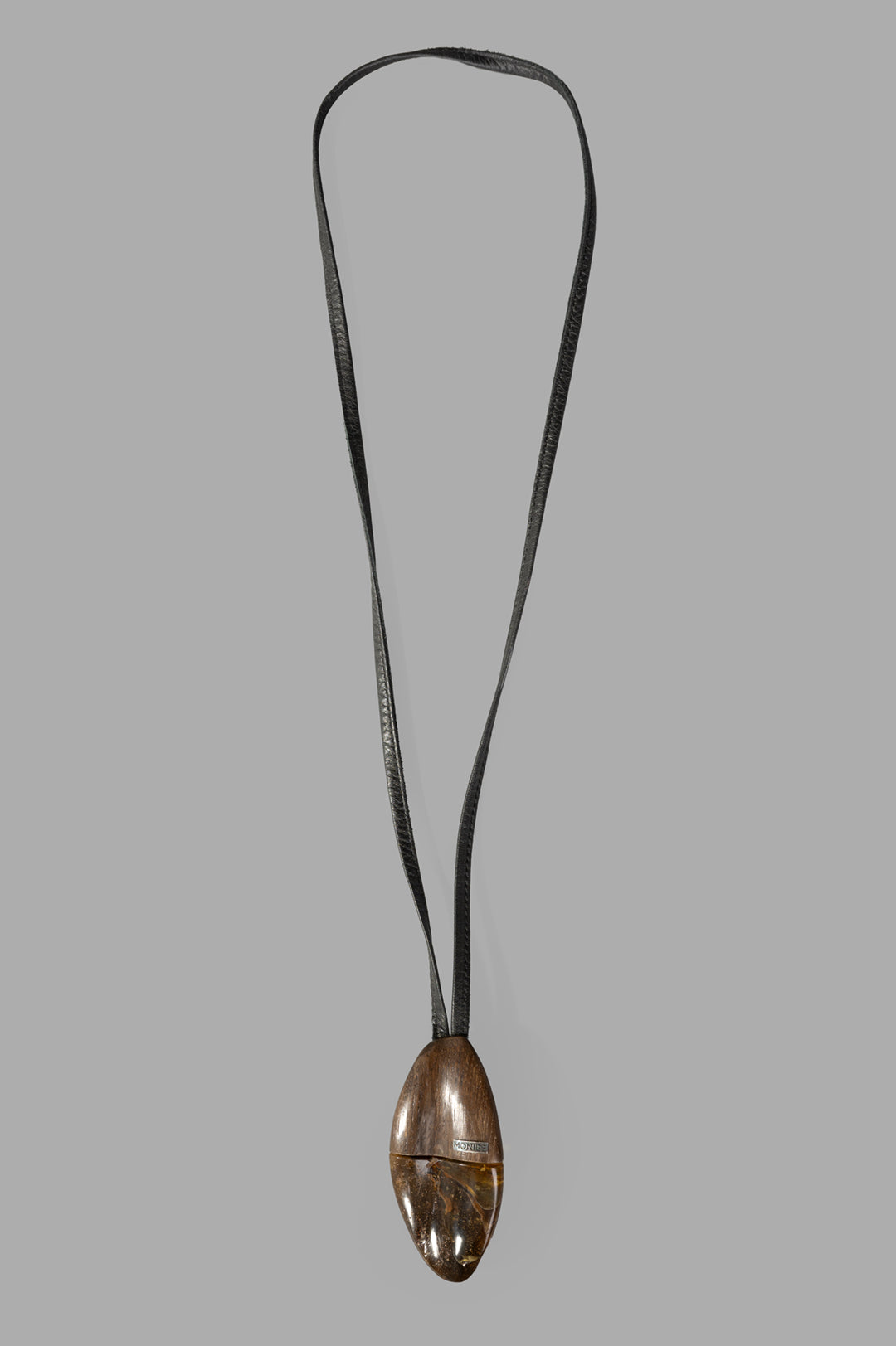 Monies Pendant Necklace, front view featuring a large brown pendant with amber stone on a sleek leather strap.