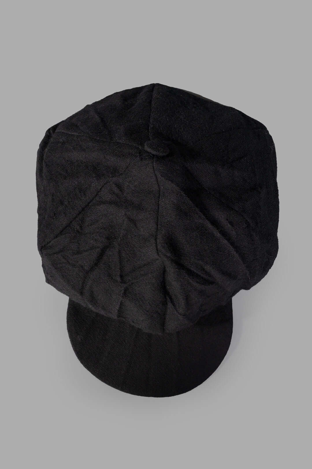 Marc Point Newsboy Cap, viewed from above, showcasing its structured top, fabric-covered button, and premium black wool.