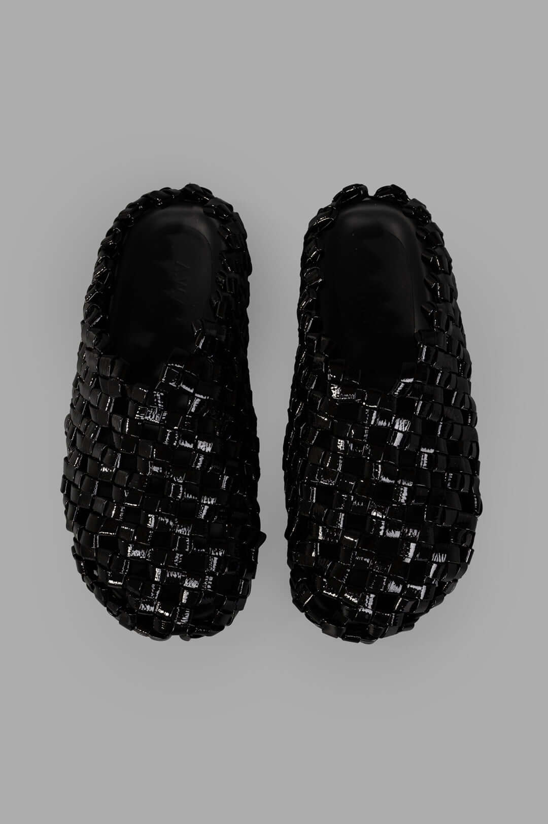 A.W.A.K.E. MODE. Weaved Clogs showcasing a stylish black woven design with a comfortable slip-on style from a top view.