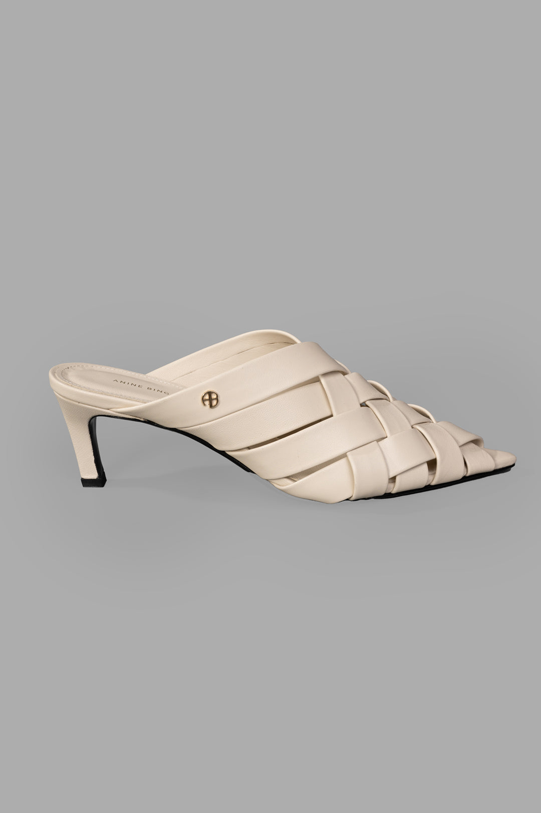 Anine Bing Eve Mules side view in bone, woven leather straps with a small heel.