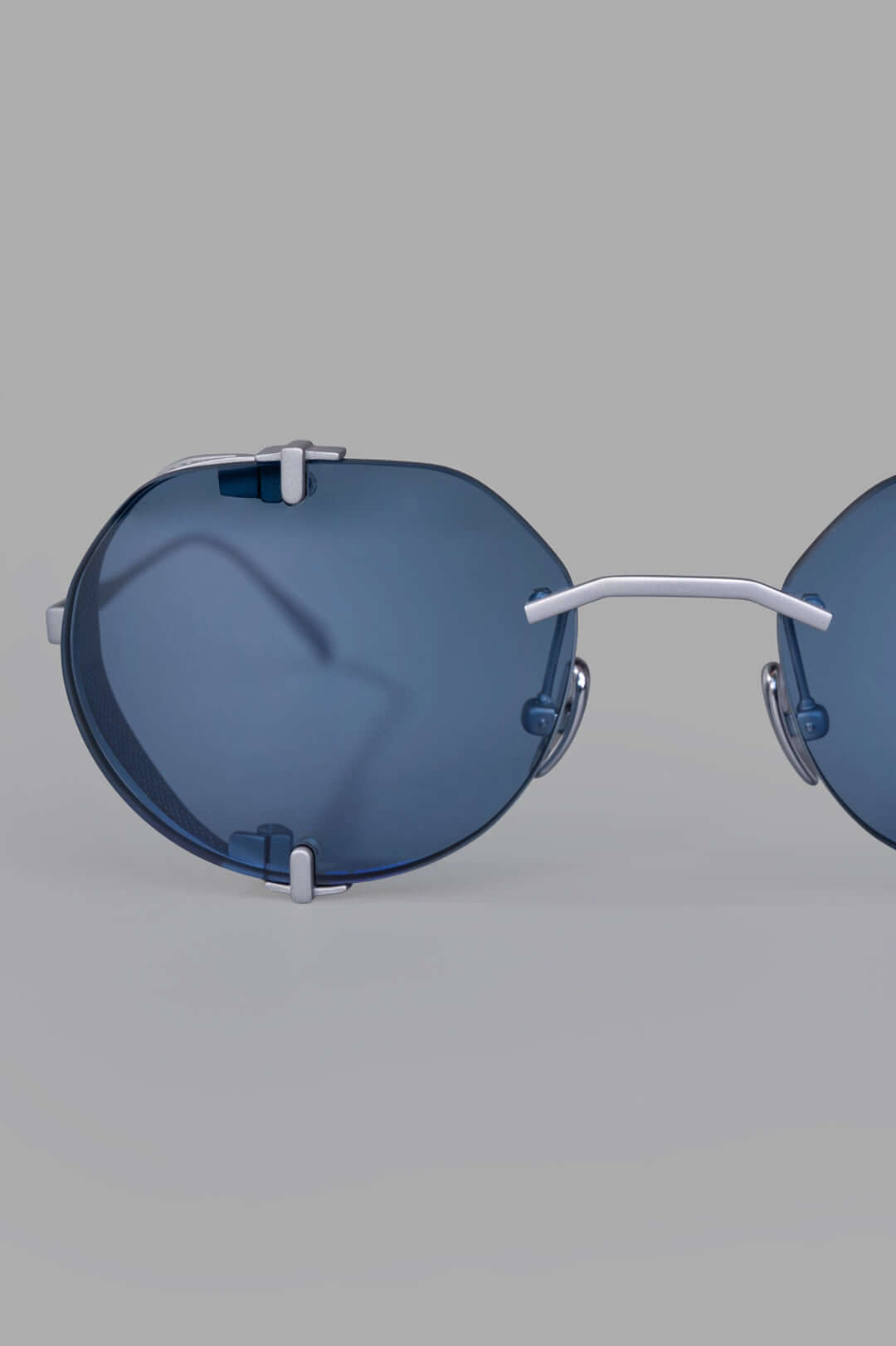 Vysen Eyewear. The Uttar - UT4 rimless titanium round frame featuring clear blue lenses and minimalist design elements.