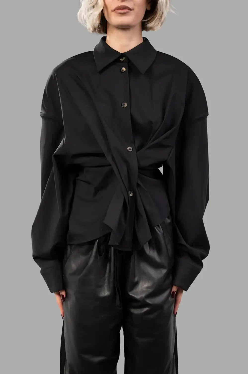 Front close-up of black twisted shirt showing spread collar, buttons and wrap detail that cinches the waist