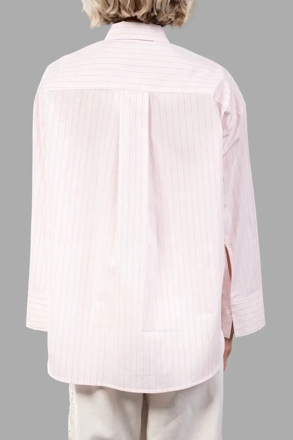Back view of pink pinstripe shirt with yoke, box pleat and curved hem