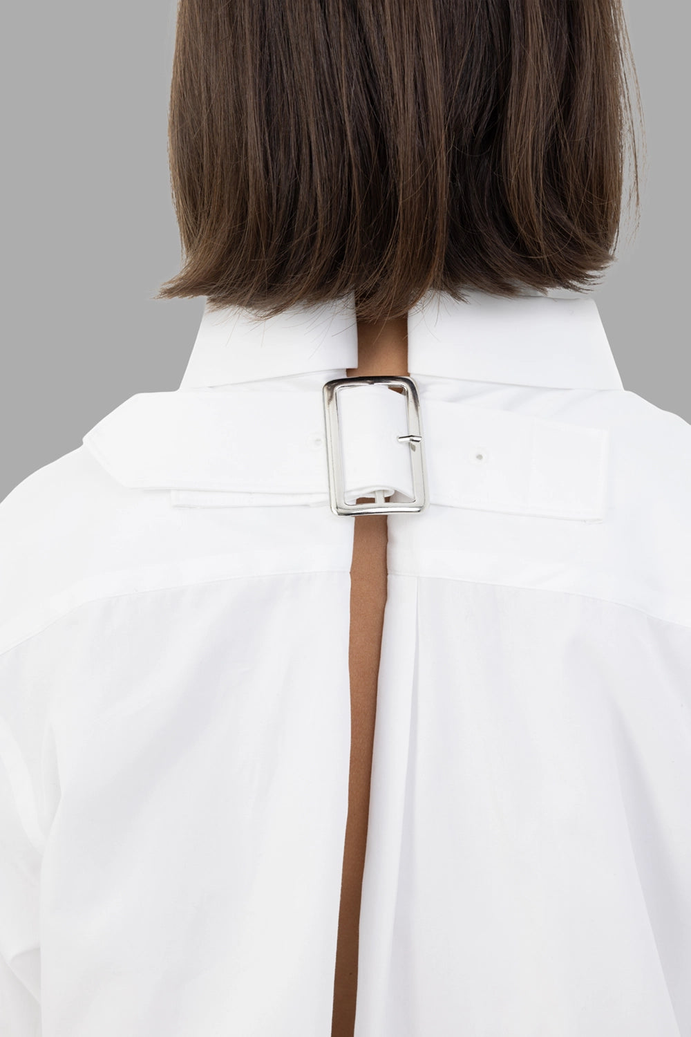 Comme des Garçons women's shirt in white, hardware close-up, silver pin-buckle strap at back neck