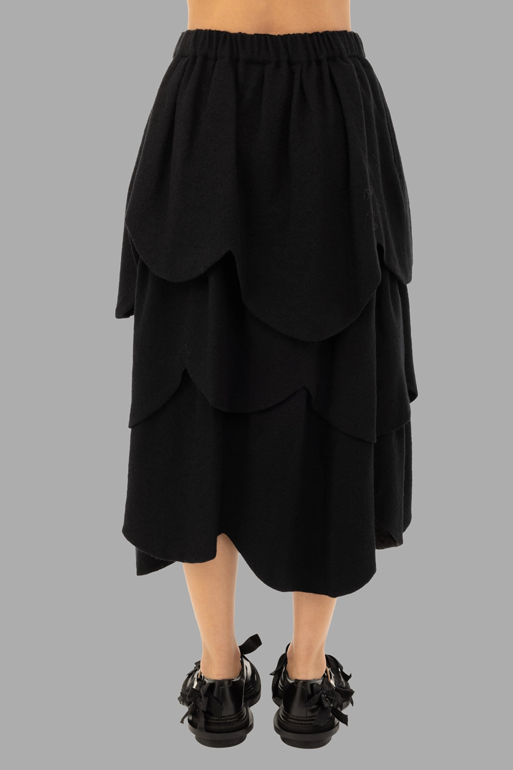 Noir Kei Ninomiya women's skirt in black, back view, layered scalloped panels and midi hem