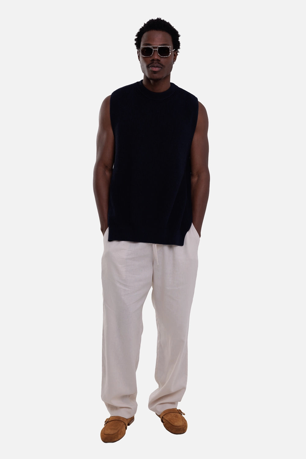AION MB men's knit vest in blue, on-model full-length view, sleeveless ribbed crew neck and straight hem