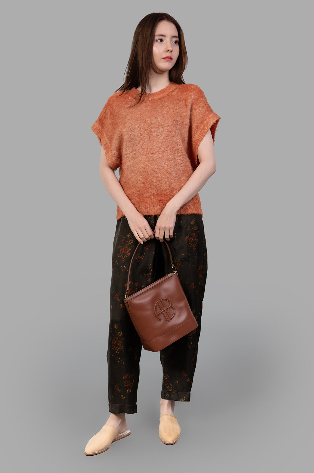Avant Toi Cap-sleeve Sweater shown on-model, front view, paired with floral pants, brown bag, and beige slip-on shoes.