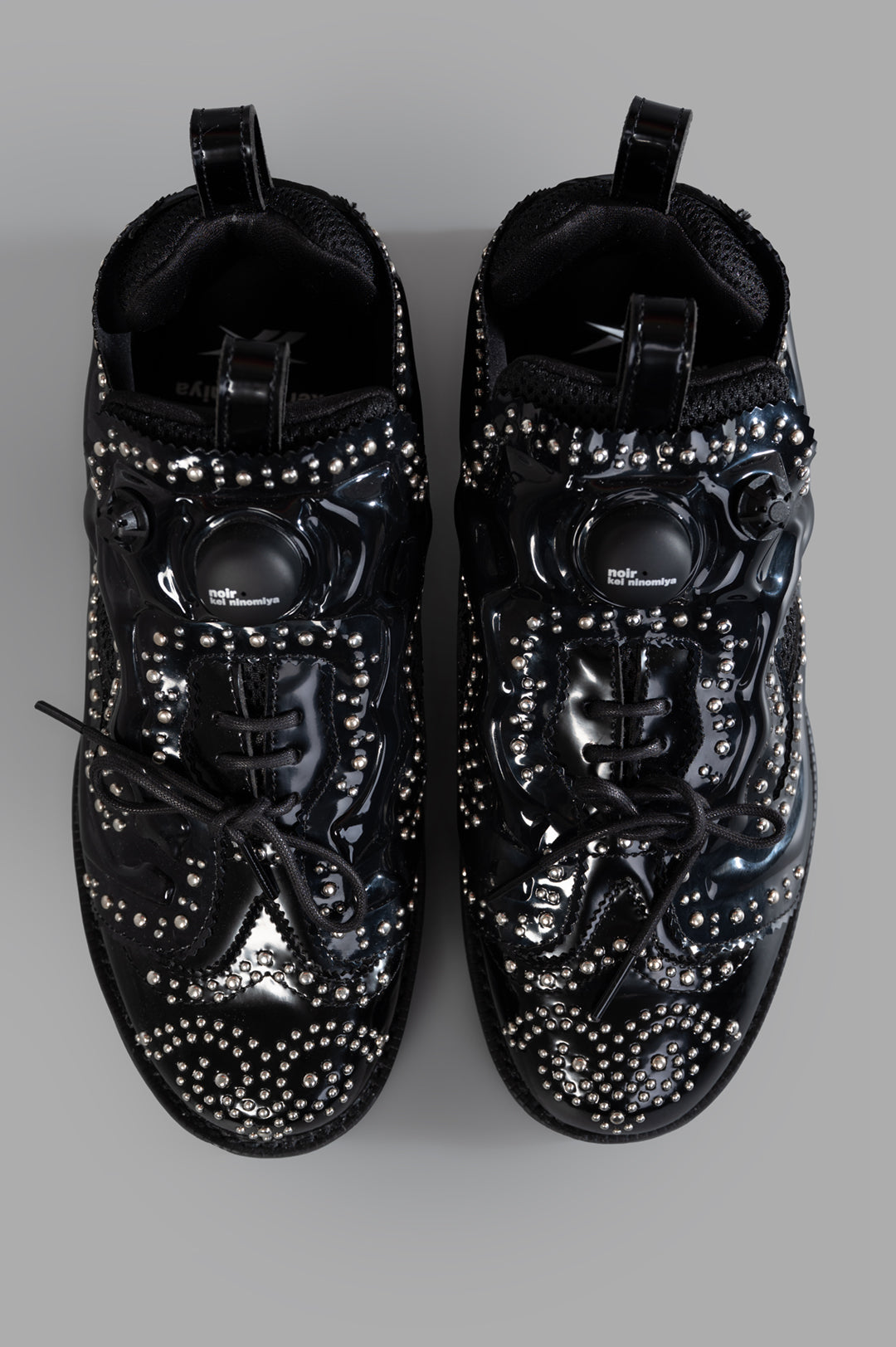 Noir Kei Ninomiya x Reebok Instapump Fury Sneakers showcasing a studded black upper and front lace-up fastening, top view.