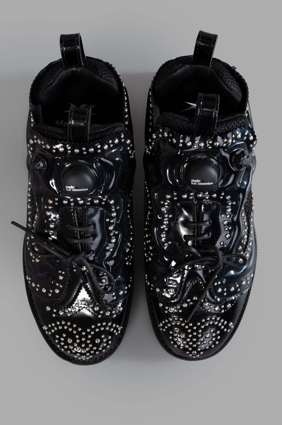 Noir Kei Ninomiya x Reebok Instapump Fury Sneakers showcasing a studded black upper and front lace-up fastening, top view.